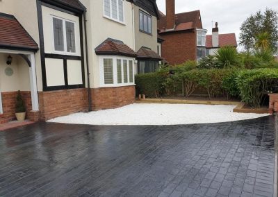 Printed concrete drive and white gravel feature
